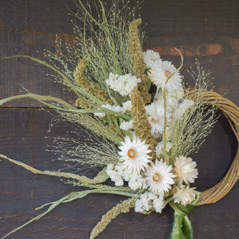 Mini Wreath - Green & White featuring white daisies and green foliage set against a dark wooden backdrop.