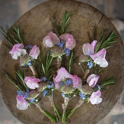 The "Design Workshop: Creating Wedding Flowers" features bouquets of pink and blue flowers with greenery arranged on a round wooden table.