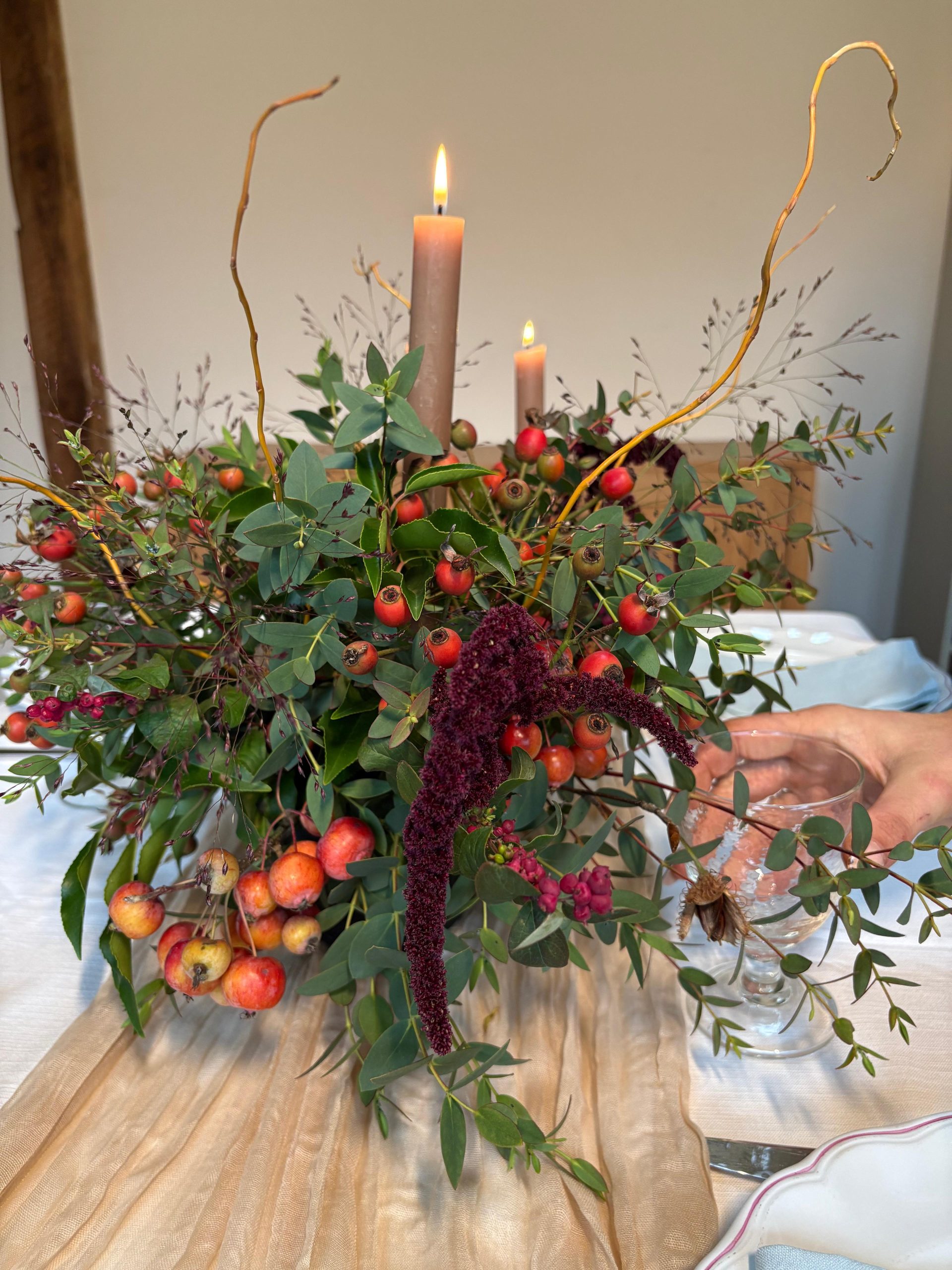 The Festive Table Centrepiece Course shows a floral display with greenery, red berries, candles, gold branches, and a hand holding a glass.